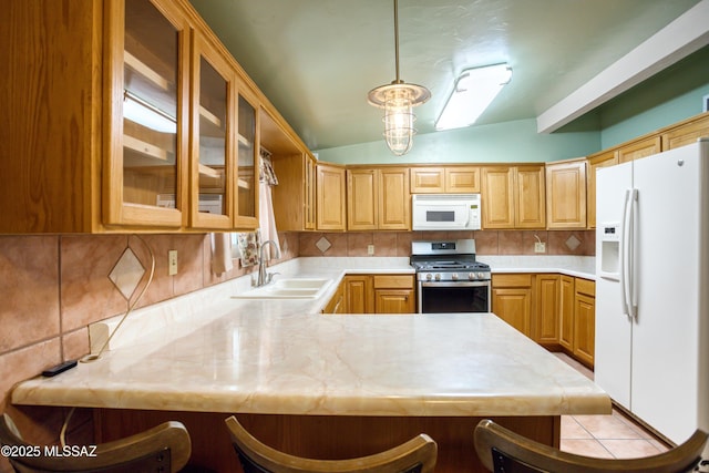 kitchen featuring white appliances, a peninsula, a sink, and light countertops