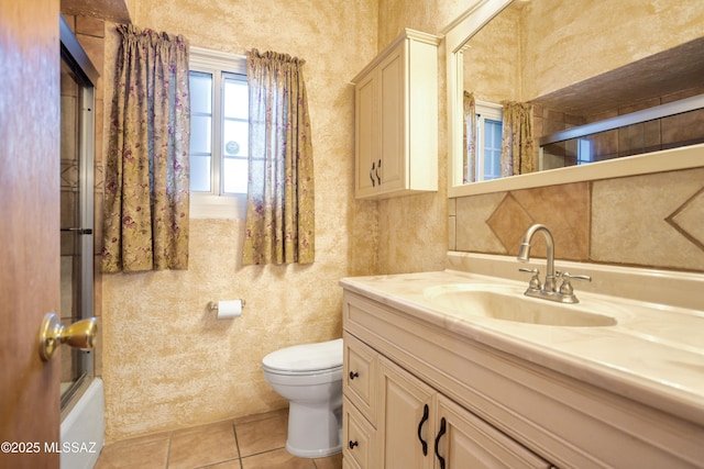 bathroom featuring vanity, tile patterned floors, bath / shower combo with glass door, and toilet