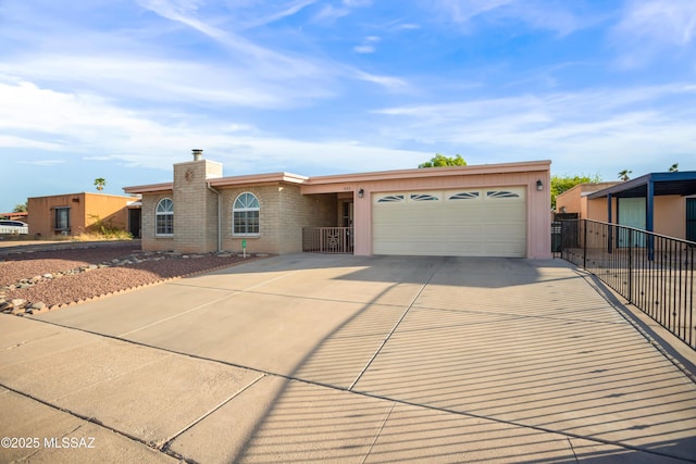 ranch-style home featuring fence, an attached garage, brick siding, a chimney, and concrete driveway