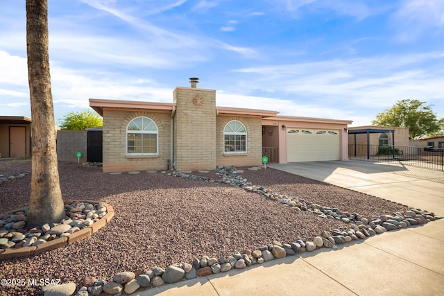 view of front of property featuring a chimney, a garage, brick siding, fence, and concrete driveway