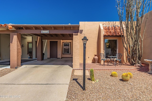 property entrance featuring stucco siding and driveway