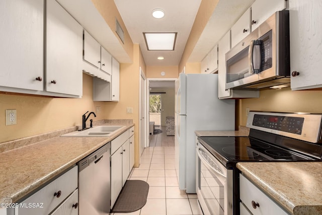 kitchen featuring visible vents, light tile patterned flooring, white cabinets, a sink, and stainless steel appliances