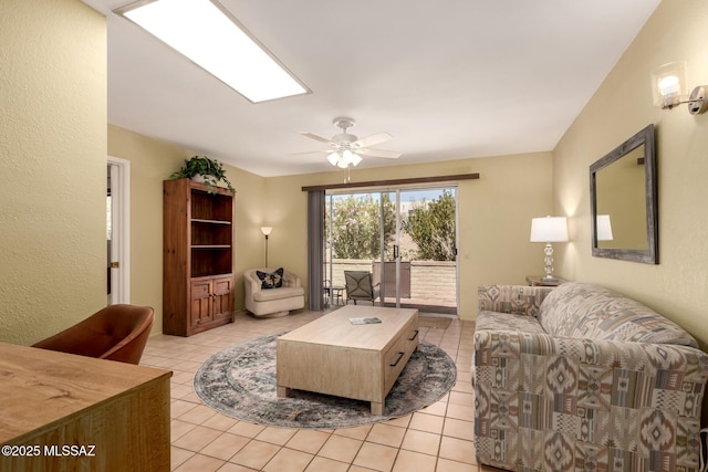 living area with a ceiling fan and light tile patterned floors