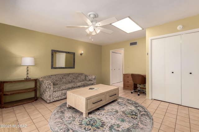 living area featuring light tile patterned floors, a ceiling fan, and visible vents
