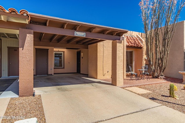 view of exterior entry featuring stucco siding and concrete driveway
