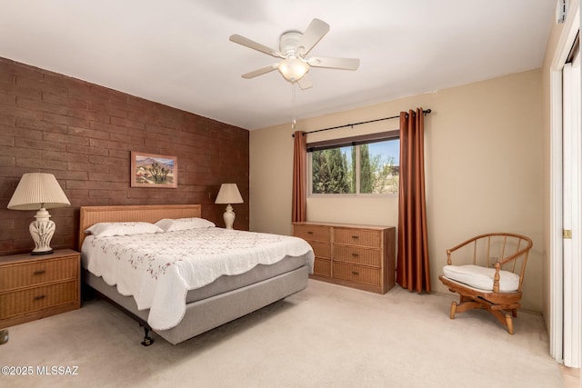 bedroom featuring a ceiling fan, brick wall, and light colored carpet