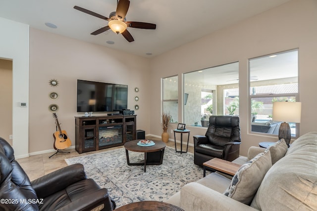 living area with baseboards and a ceiling fan