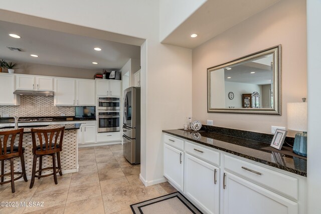 2594 E Keyes Ct, Green Valley, AZ 85614 - kitchen with a sink, tasteful backsplash, gas cooktop, under cabinet range hood, and white cabinetry