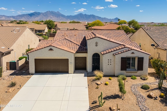 mediterranean / spanish home featuring concrete driveway, an attached garage, a tile roof, and stucco siding
