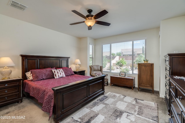 bedroom with visible vents, ceiling fan, and light carpet