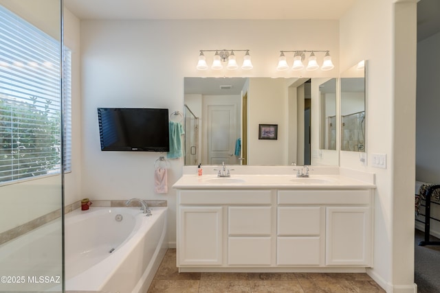 bathroom featuring double vanity, a sink, a garden tub, and a stall shower