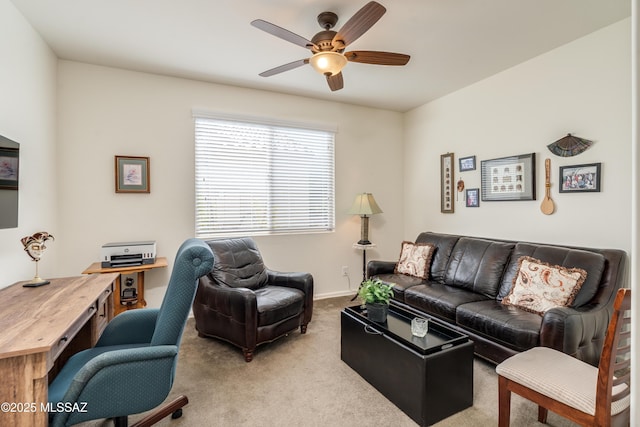 carpeted living room featuring a ceiling fan and baseboards