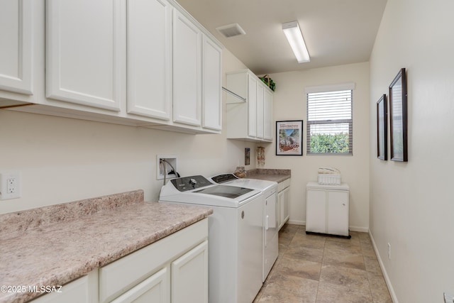 clothes washing area with baseboards, cabinet space, visible vents, and washing machine and clothes dryer