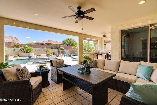 view of patio / terrace with a fenced backyard, ceiling fan, an outdoor living space, and exterior kitchen
