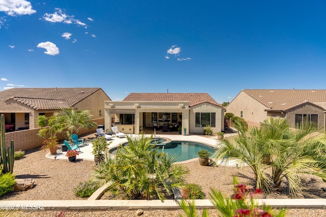 view of swimming pool with fence, a pool with connected hot tub, and a patio area