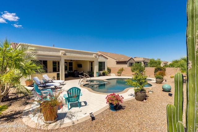 view of pool featuring a pool with connected hot tub, outdoor lounge area, a fenced backyard, a patio area, and a ceiling fan