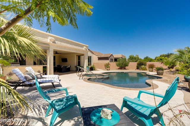 view of pool with ceiling fan, a pool with connected hot tub, a fenced backyard, a patio, and outdoor lounge area