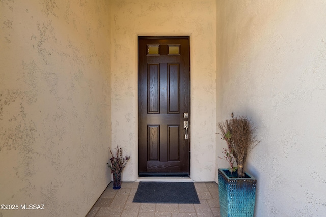 entrance to property featuring stucco siding
