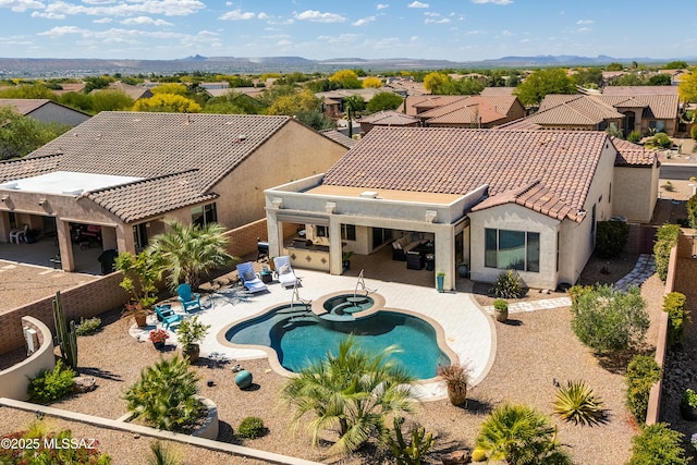view of swimming pool featuring a fenced backyard, a patio, a pool with connected hot tub, and a residential view