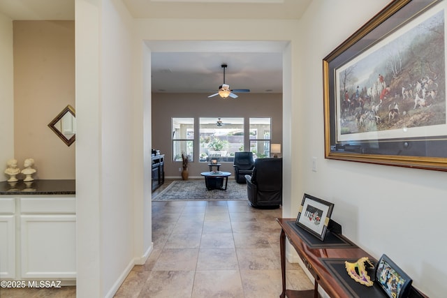 hall with baseboards and light tile patterned floors