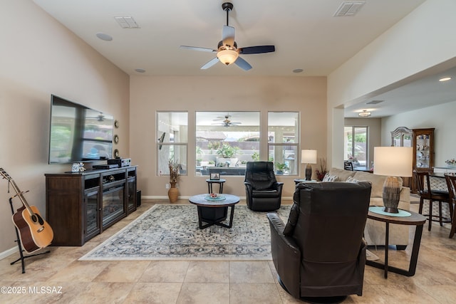 living room with a ceiling fan, baseboards, and visible vents