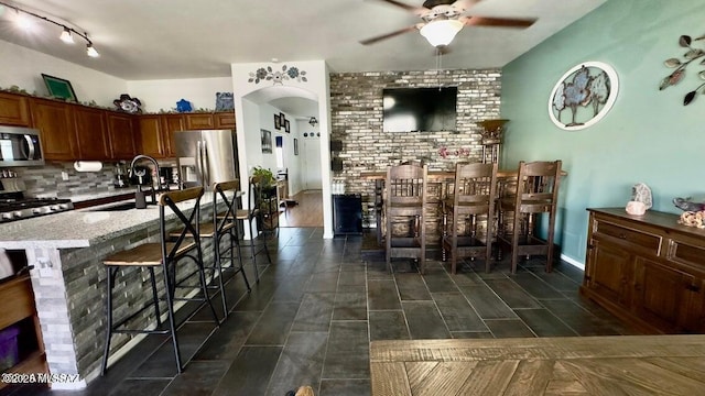 630 E Racine Pl, Casa Grande, AZ 85122 - interior space featuring a ceiling fan, arched walkways, tasteful backsplash, a sink, and stainless steel appliances