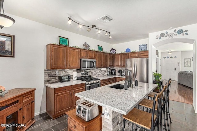 630 E Racine Pl, Casa Grande, AZ 85122 - kitchen featuring visible vents, arched walkways, tasteful backsplash, a sink, and appliances with stainless steel finishes