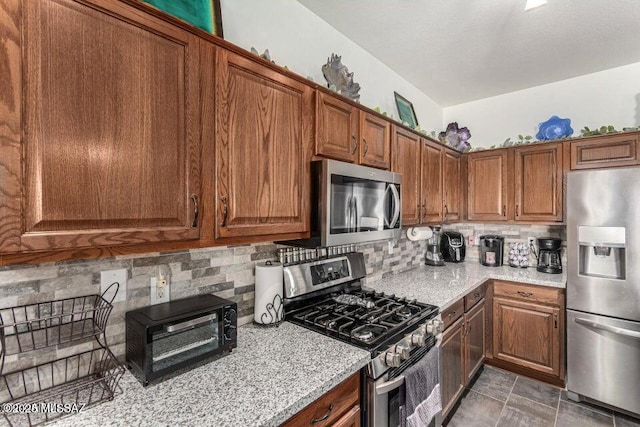630 E Racine Pl, Casa Grande, AZ 85122 - kitchen with brown cabinets, tasteful backsplash, and stainless steel appliances