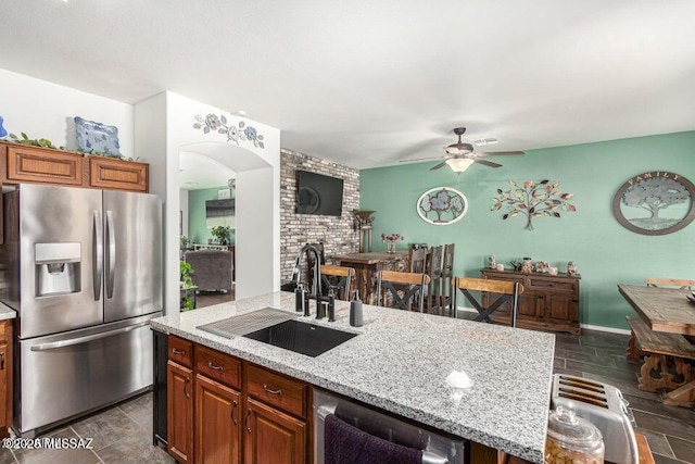 630 E Racine Pl, Casa Grande, AZ 85122 - kitchen featuring light stone countertops, an island with sink, ceiling fan, a sink, and appliances with stainless steel finishes