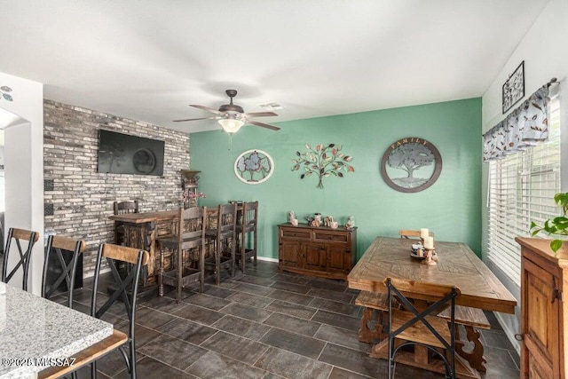 630 E Racine Pl, Casa Grande, AZ 85122 - dining area with a ceiling fan, brick wall, visible vents, and an accent wall