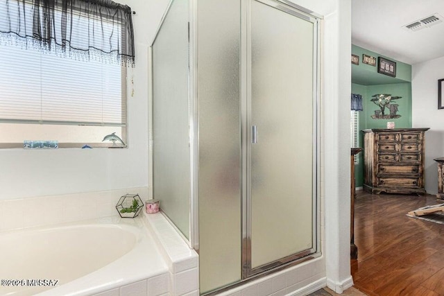 630 E Racine Pl, Casa Grande, AZ 85122 - bathroom with visible vents, wood finished floors, a bath, and a stall shower