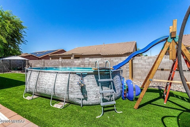 630 E Racine Pl, Casa Grande, AZ 85122 - view of swimming pool featuring a yard, a fenced in pool, a fenced backyard, and a playground
