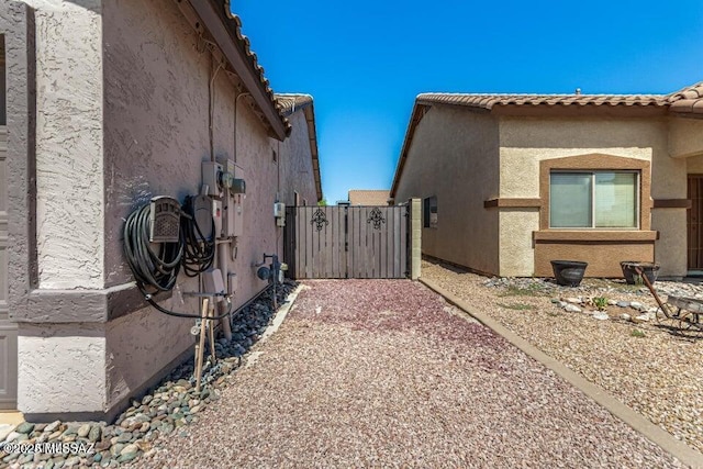 630 E Racine Pl, Casa Grande, AZ 85122 - view of home's exterior featuring a gate, stucco siding, and a tile roof