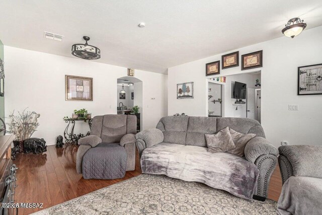 630 E Racine Pl, Casa Grande, AZ 85122 - living room featuring arched walkways, visible vents, and wood finished floors