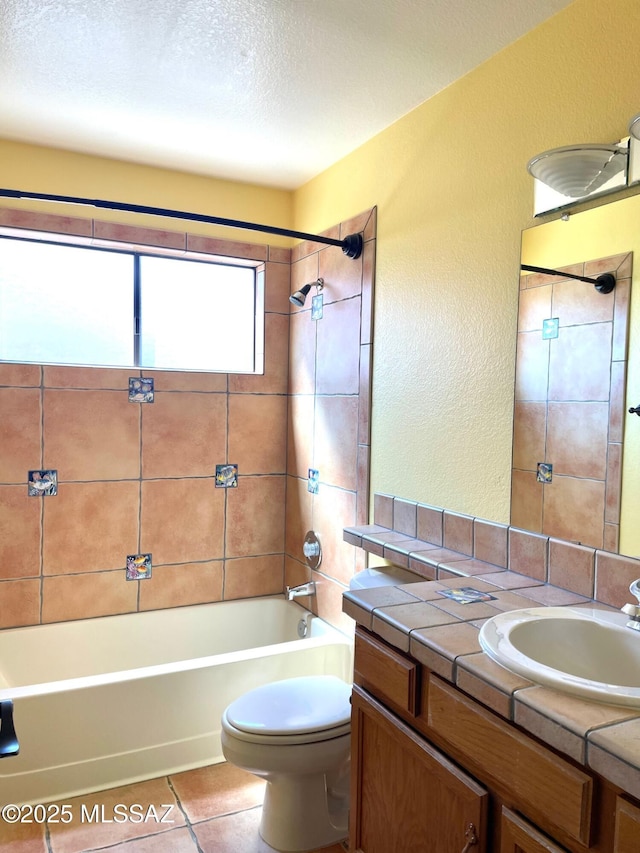 full bath featuring a textured wall, tile patterned flooring, vanity, toilet, and shower / bathing tub combination