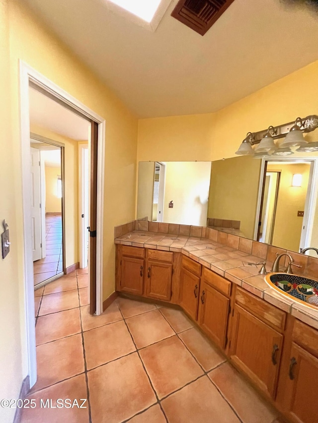 bathroom with visible vents, a sink, and tile patterned floors