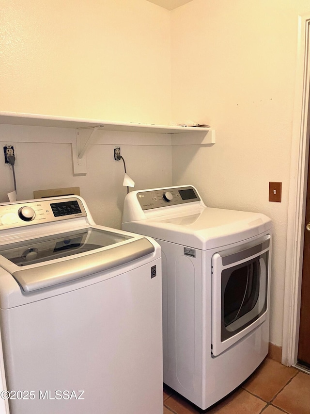 washroom with light tile patterned floors, laundry area, and washer and clothes dryer