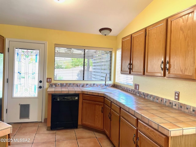 kitchen with tile counters, light tile patterned floors, a sink, and dishwasher