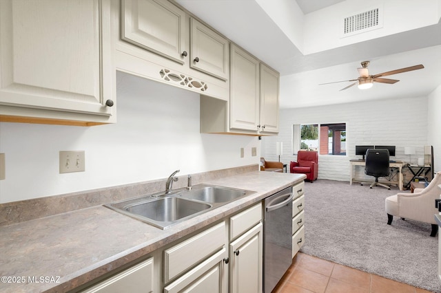 kitchen featuring visible vents, dishwasher, a sink, light countertops, and light carpet