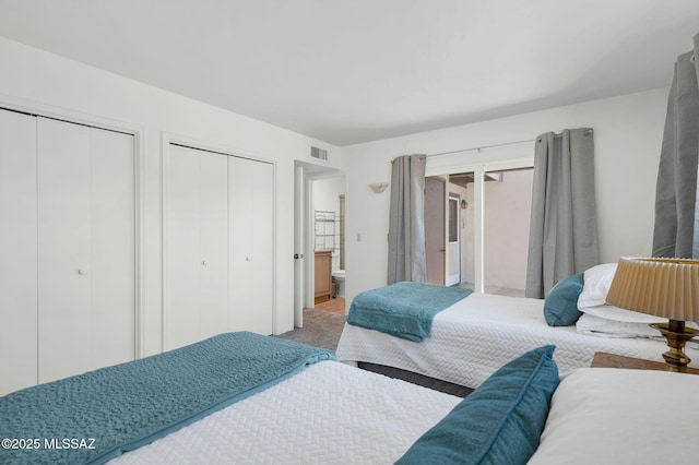 bedroom featuring two closets and visible vents