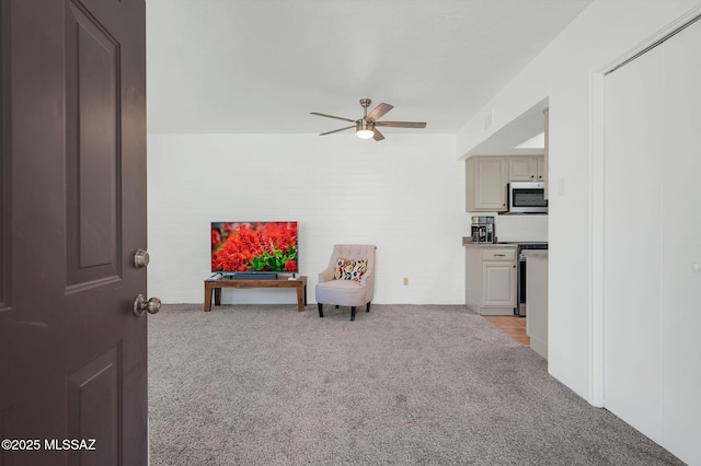 living area featuring light carpet, a ceiling fan, and visible vents