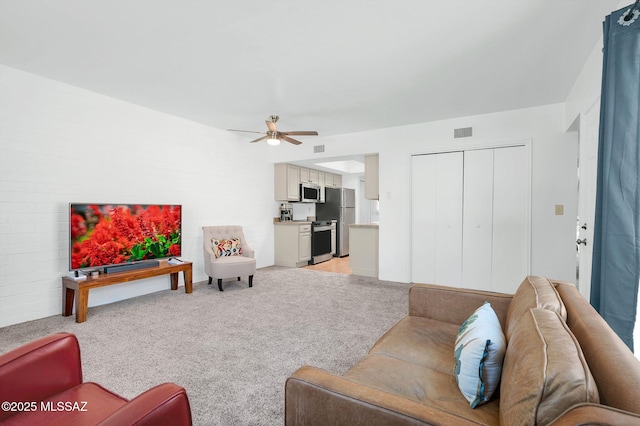 living area featuring ceiling fan, light carpet, and visible vents