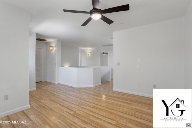 unfurnished room featuring visible vents, a ceiling fan, light wood-style floors, and baseboards