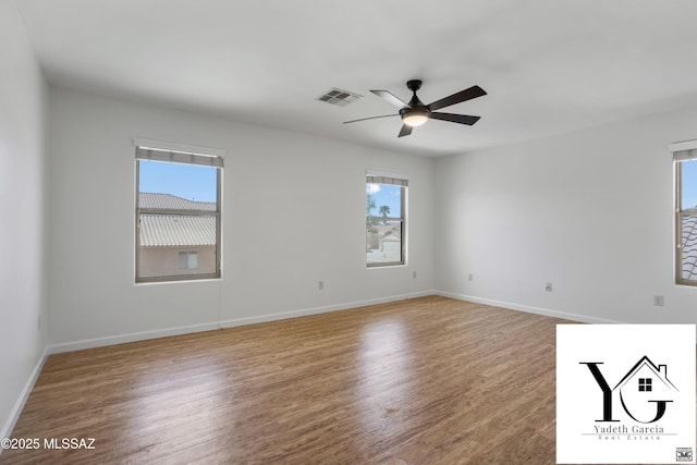 spare room featuring visible vents, ceiling fan, and a wealth of natural light