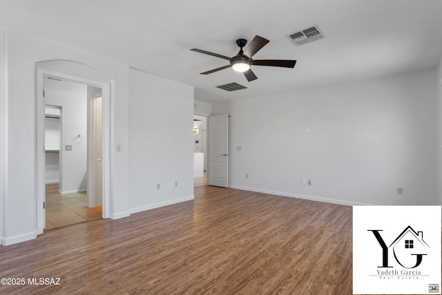interior space with baseboards, wood finished floors, and visible vents