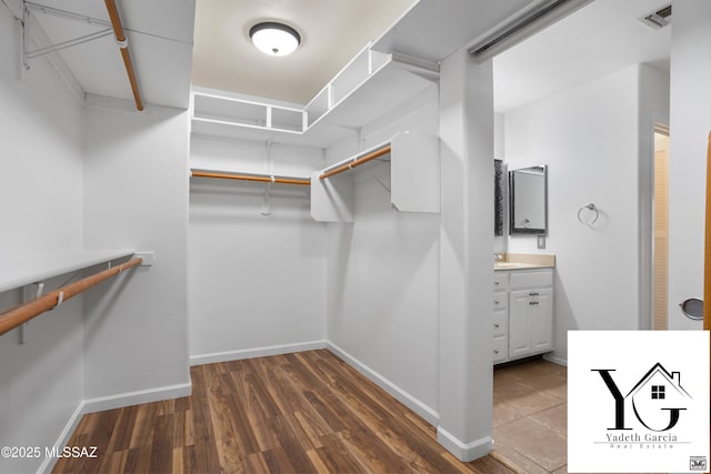 spacious closet with a sink, wood finished floors, and visible vents