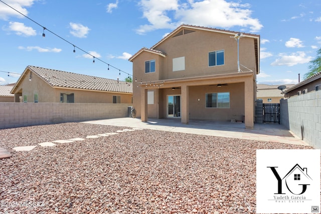 rear view of house with a fenced backyard, stucco siding, and a patio area