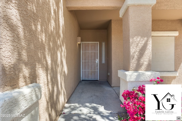 doorway to property featuring stucco siding