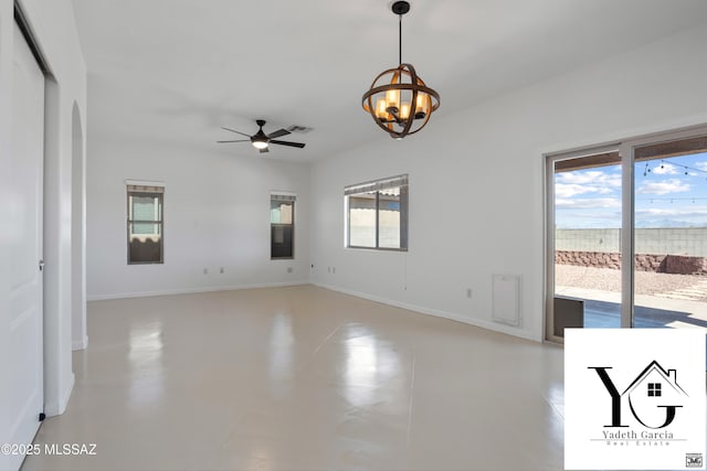 empty room featuring visible vents, baseboards, ceiling fan with notable chandelier, and a wealth of natural light