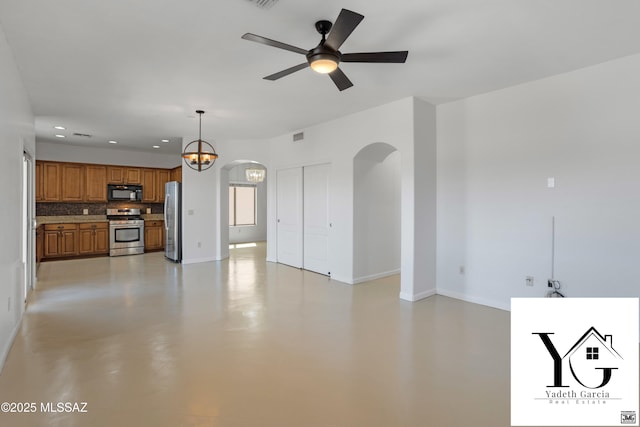 unfurnished living room featuring arched walkways, ceiling fan, recessed lighting, and baseboards